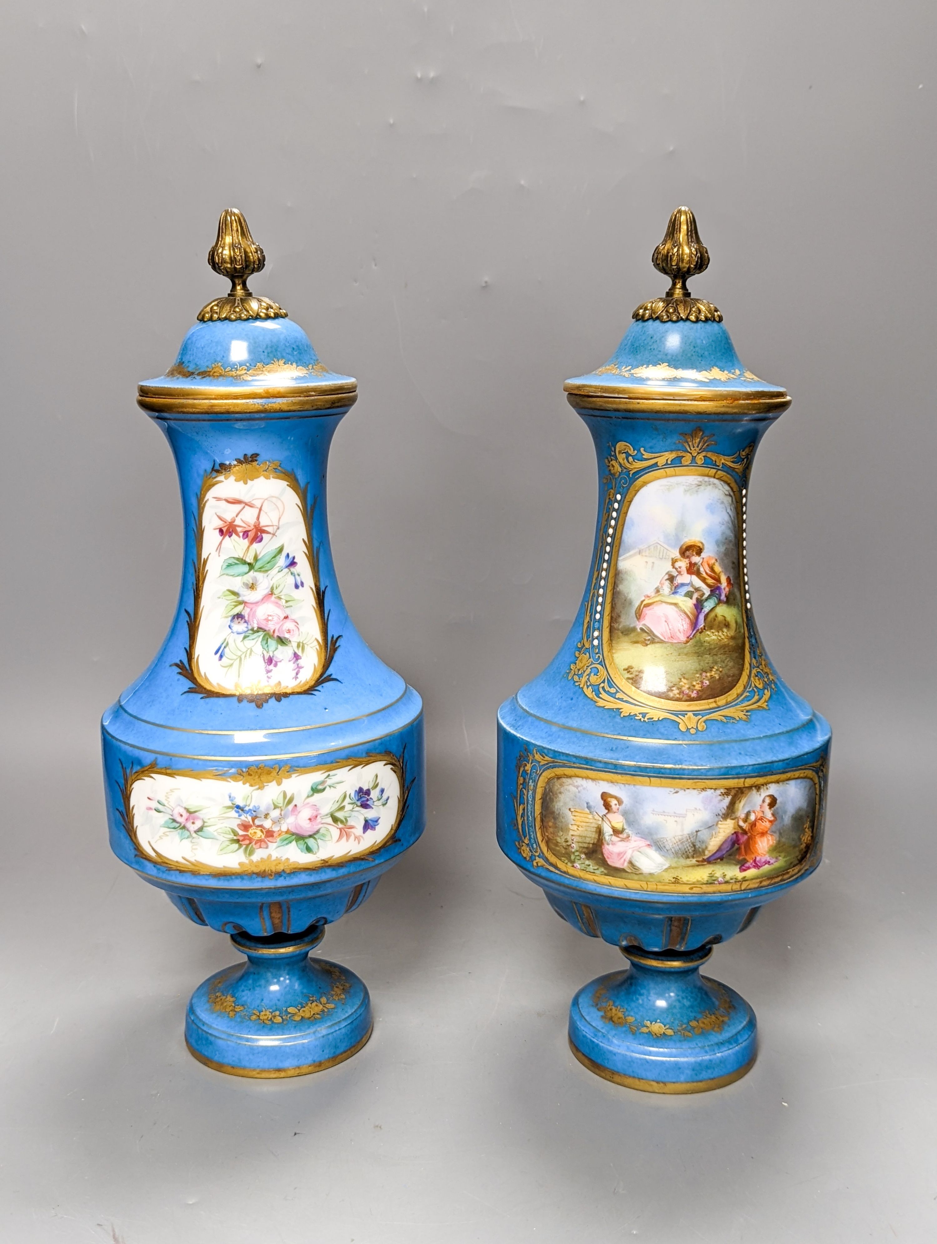 A pair of Sevres style porcelain bleu celeste ground vases and covers, 34cm